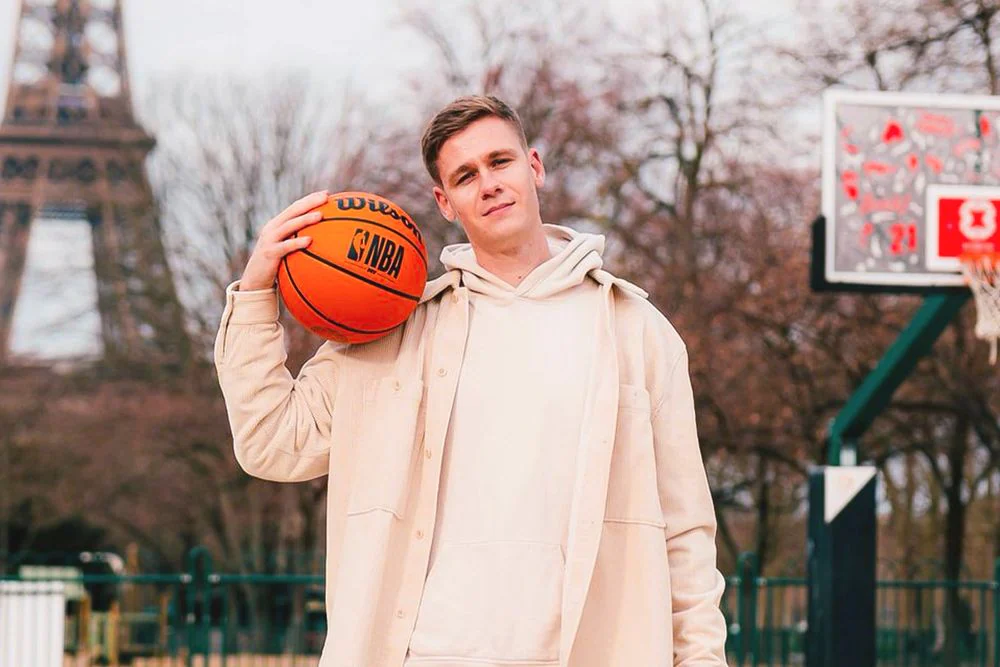 Florian Gautier, créateur de Deux Nuits Avec, un ballon de basket à la main devant la tour Eiffel